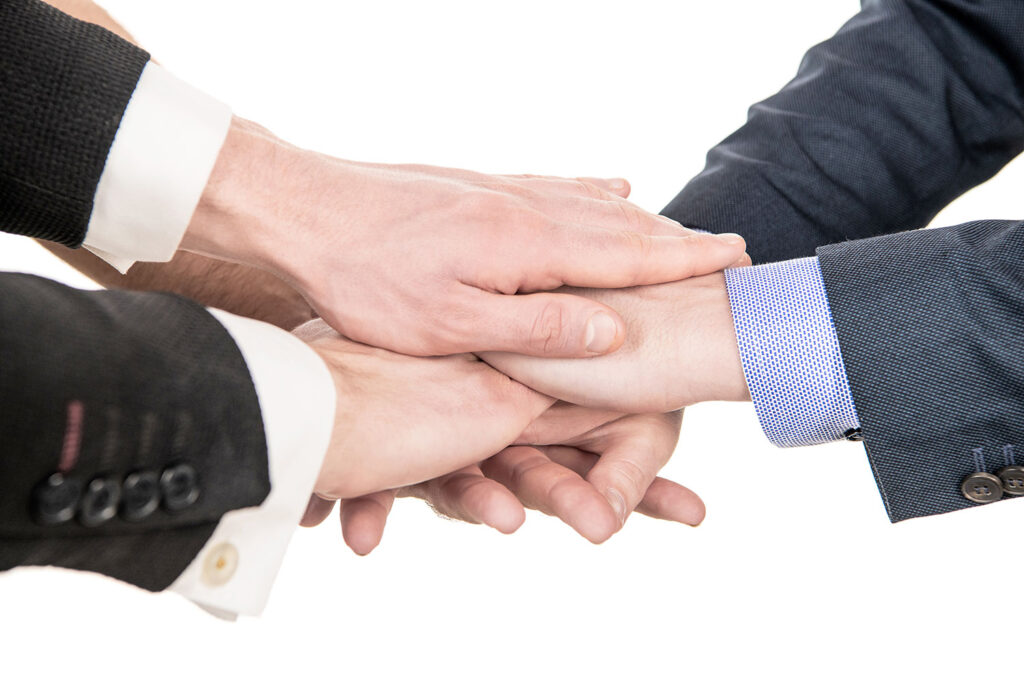 Współpracownicy podają sobie ręce w geście wyrażenia chęci współpracy.