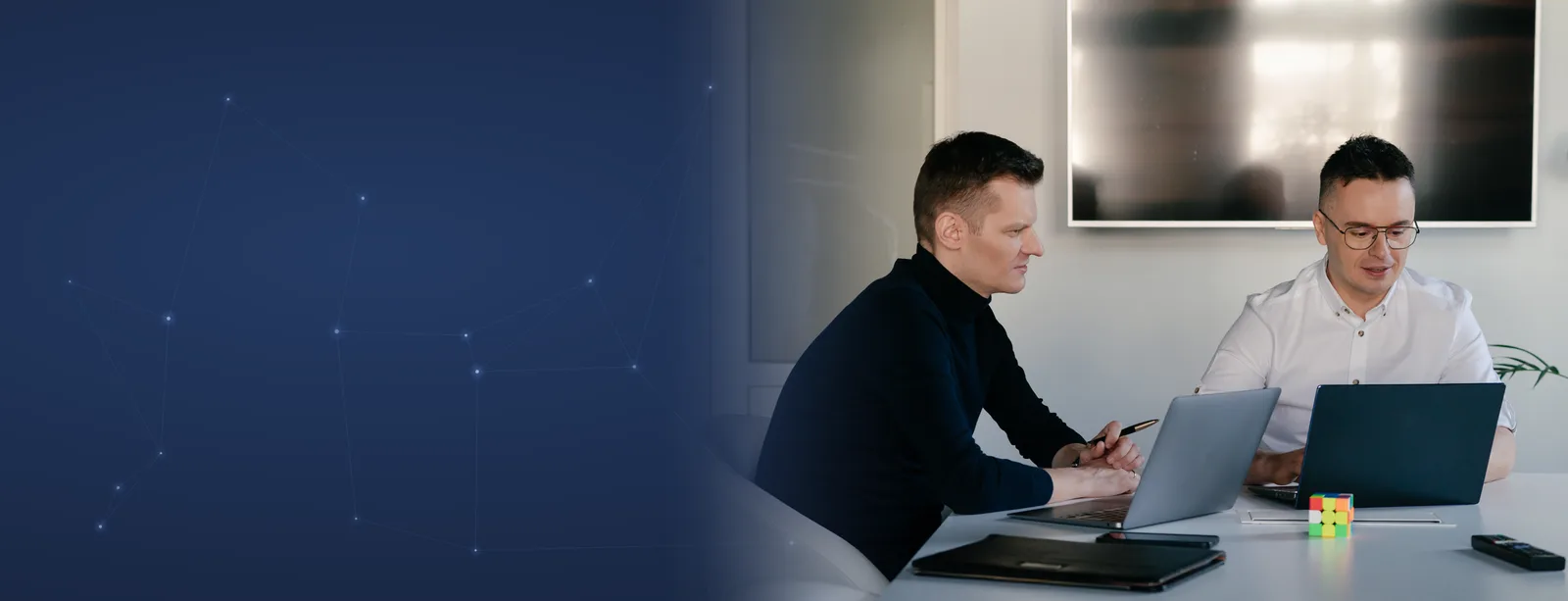 Grzegorz Wysocki z emedia omawia projekt przy laptopach w biurze
